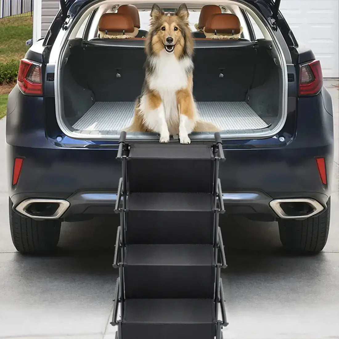 A black multi-step pet car ramp is shown deployed between the open trunk of a dark SUV and a dog sitting on the trunk, demonstrating its use in a real-world garage environment.