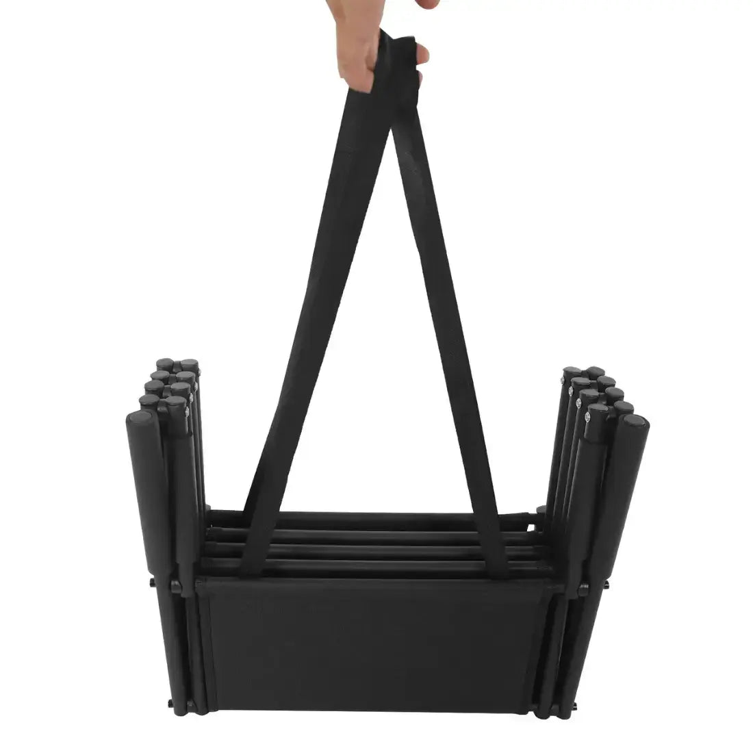 A black folding table with integrated carrying straps, held up by a hand against a plain white background.