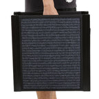 Person holding a large black folding dog ramp against a white background